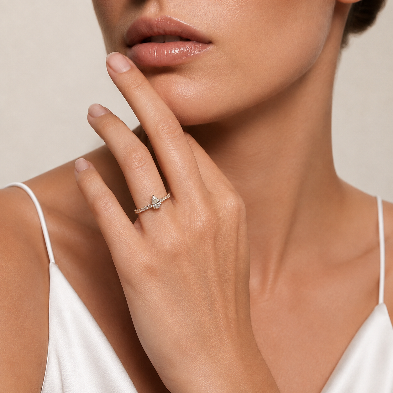 Birnenförmiger Diamantring mit runden Seitensteinen | 18K