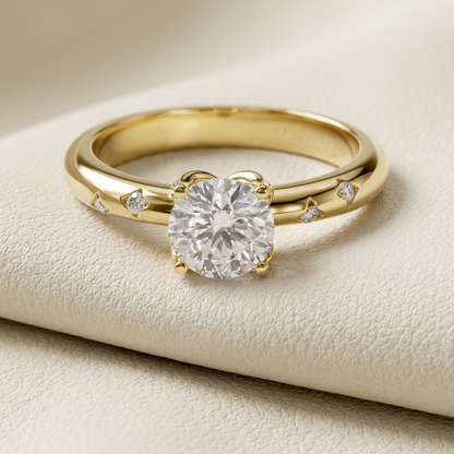 Yellow gold solitaire ring with round diamond and scattered accents
Elegant round diamond ring featuring delicate floating accent stones
Luxury gold engagement ring with brilliant solitaire center diamond
Modern yellow gold ring with scattered diamond details
Unique solitaire diamond ring with a polished curved gold band
Fine jewelry ring featuring a brilliant round center stone
Contemporary gold engagement ring with subtle diamond accents
Sparkling round solitaire ring displayed on an ivory surface
Designe