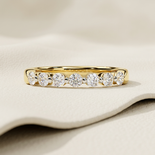 Yellow gold band with graduated round diamond row
Brilliant round diamonds aligned across an open gallery setting
Elegant gold band featuring seven sparkling diamond accents
Graduated diamonds arranged in a balanced curved sequence
Polished yellow gold band showcasing prominent round cut stones
Refined diamond band with larger center stones and tapered sides
Fine jewelry band featuring symmetrical brilliant diamond placement
Radiant round diamonds displayed within a sleek open gold frame
Contemporary gold b