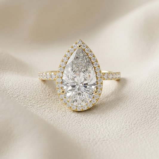 Pear halo solitaire diamond ring in yellow gold.
Yellow gold pear halo diamond ring.
Pear-shaped halo engagement ring.
Pear cut diamond halo ring.
Elegant pear halo solitaire ring.
Gold pear diamond engagement ring.
Luxury pear halo diamond ring.
Pear solitaire with pavé halo.
Classic pear halo diamond ring.
Pear-shaped solitaire ring with halo.